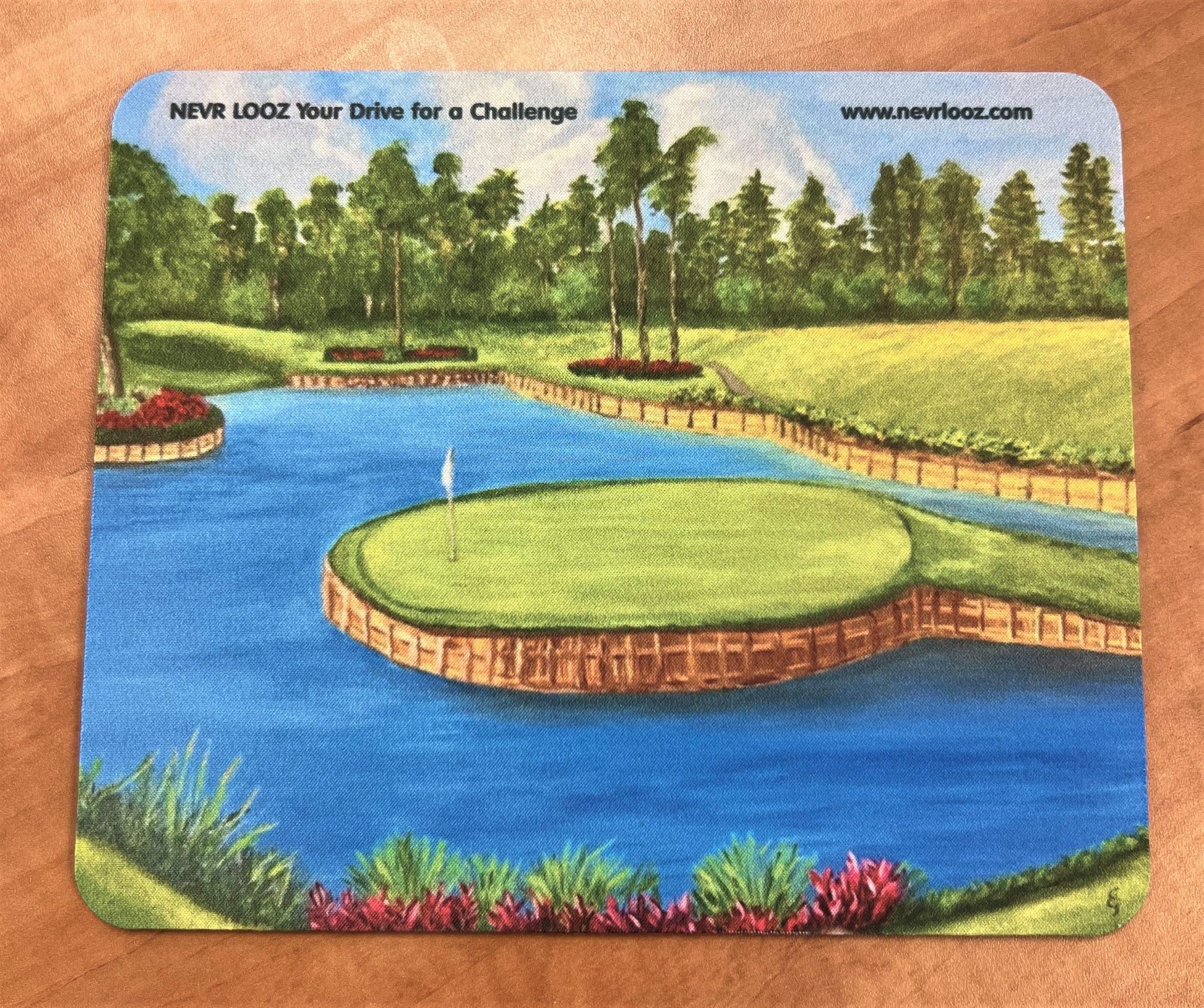 Mousepad featuring a print of the famous 17th hole at TPC Sawgrass, with a golf course, pond, and trees in a serene outdoor landscape.